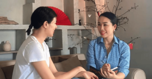 a woman sitting on a couch talking to another woman